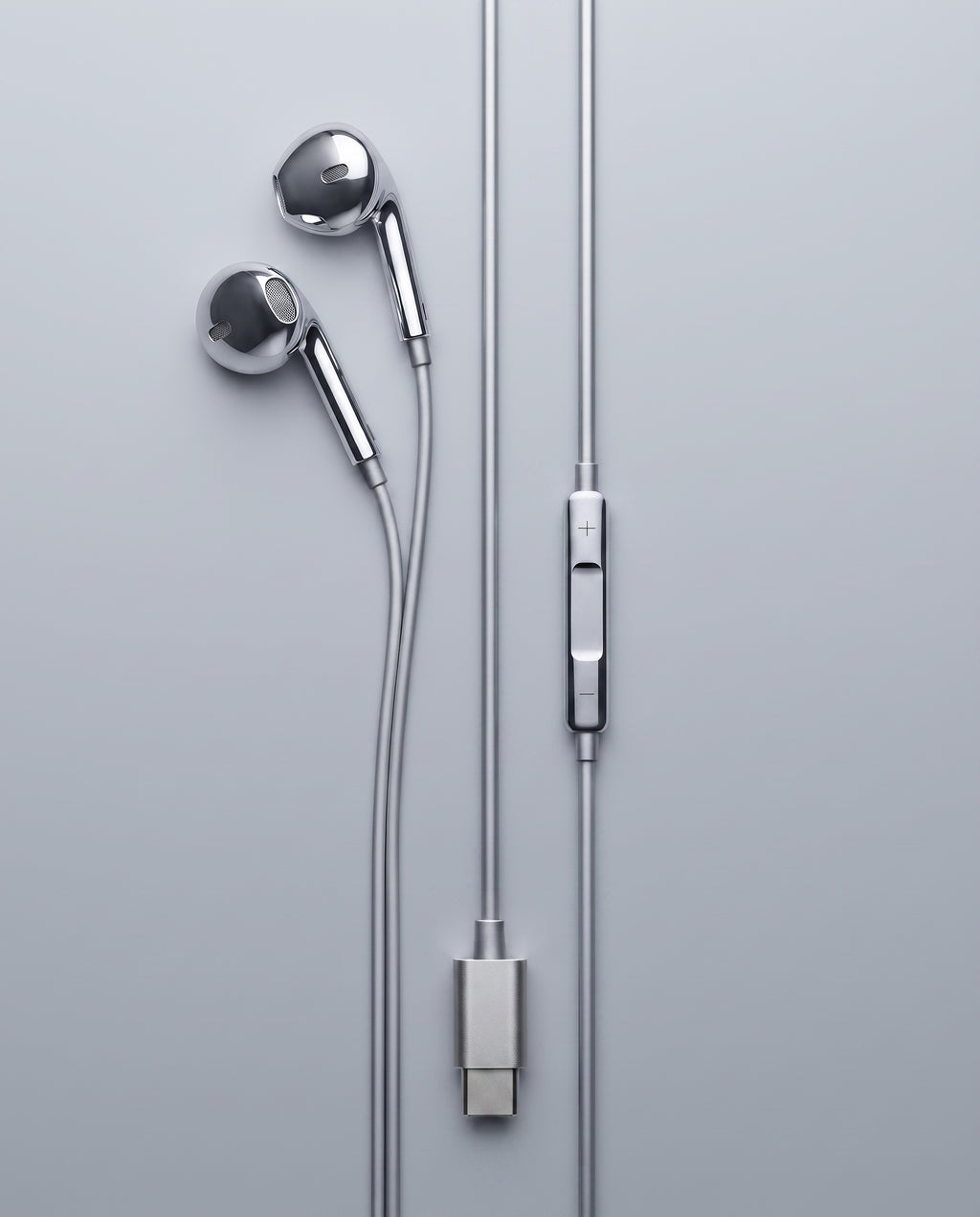 USB-C chrome wired earbuds laid flat, chrome inline volume control and brushed USB-C connector