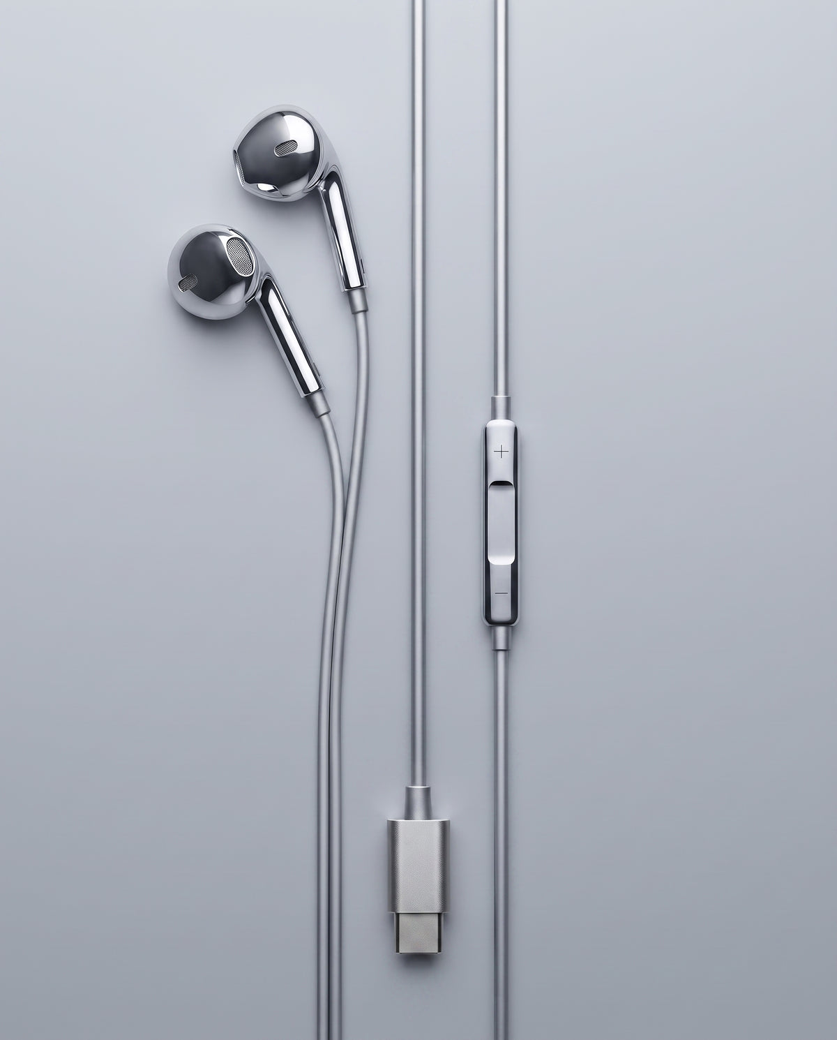 USB-C chrome wired earbuds laid flat, chrome inline volume control and brushed USB-C connector