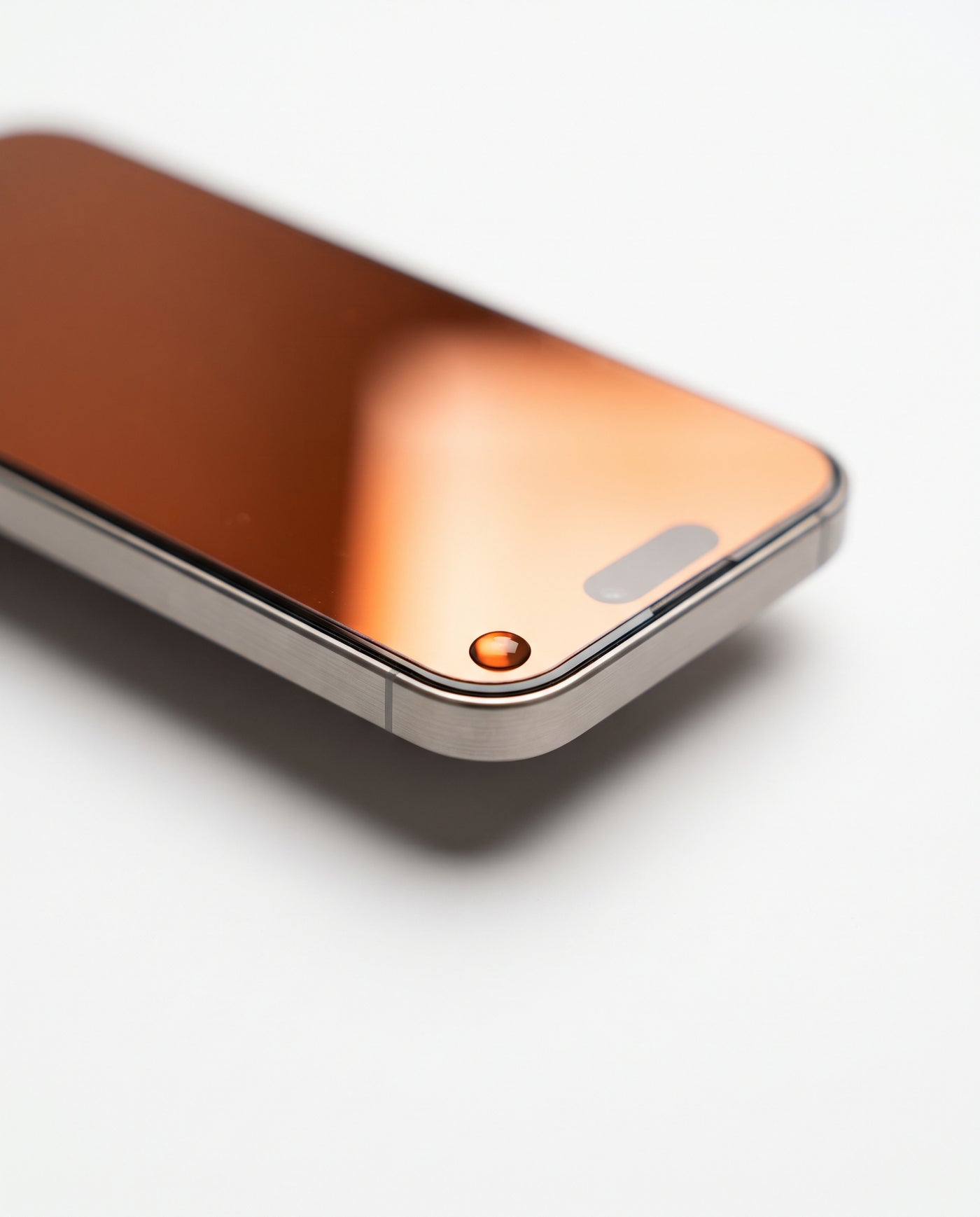 Cosmic Orange | Macro — protector edge, polished 2.5D edge, water bead, orange tint at an angle